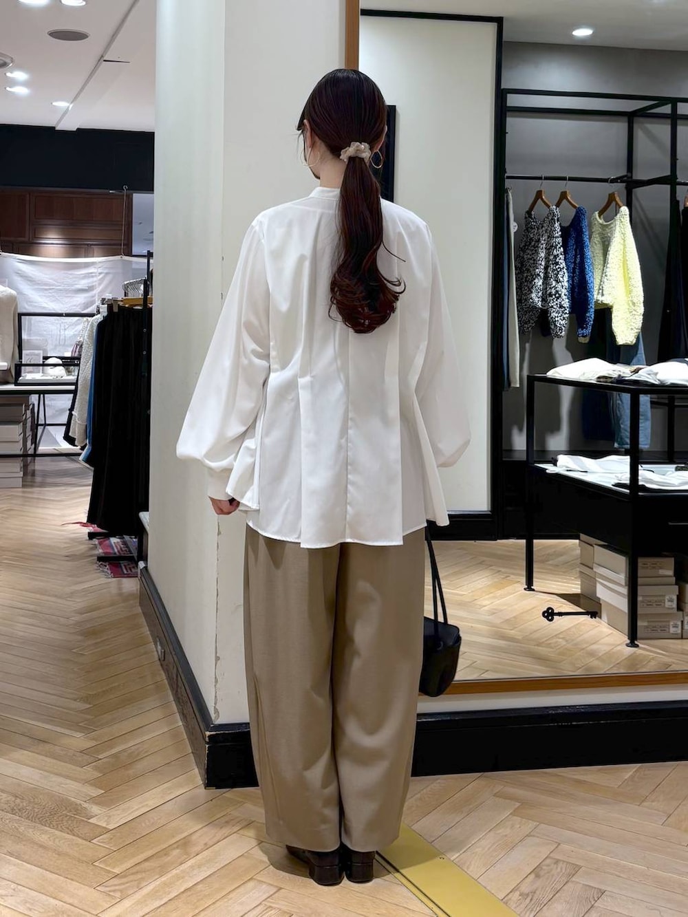 ベージュ系のスラックス、ブラック系のローファー、ホワイト系のTシャツ/カットソーを着用したレディースの冬コーディネートの7枚目の写真