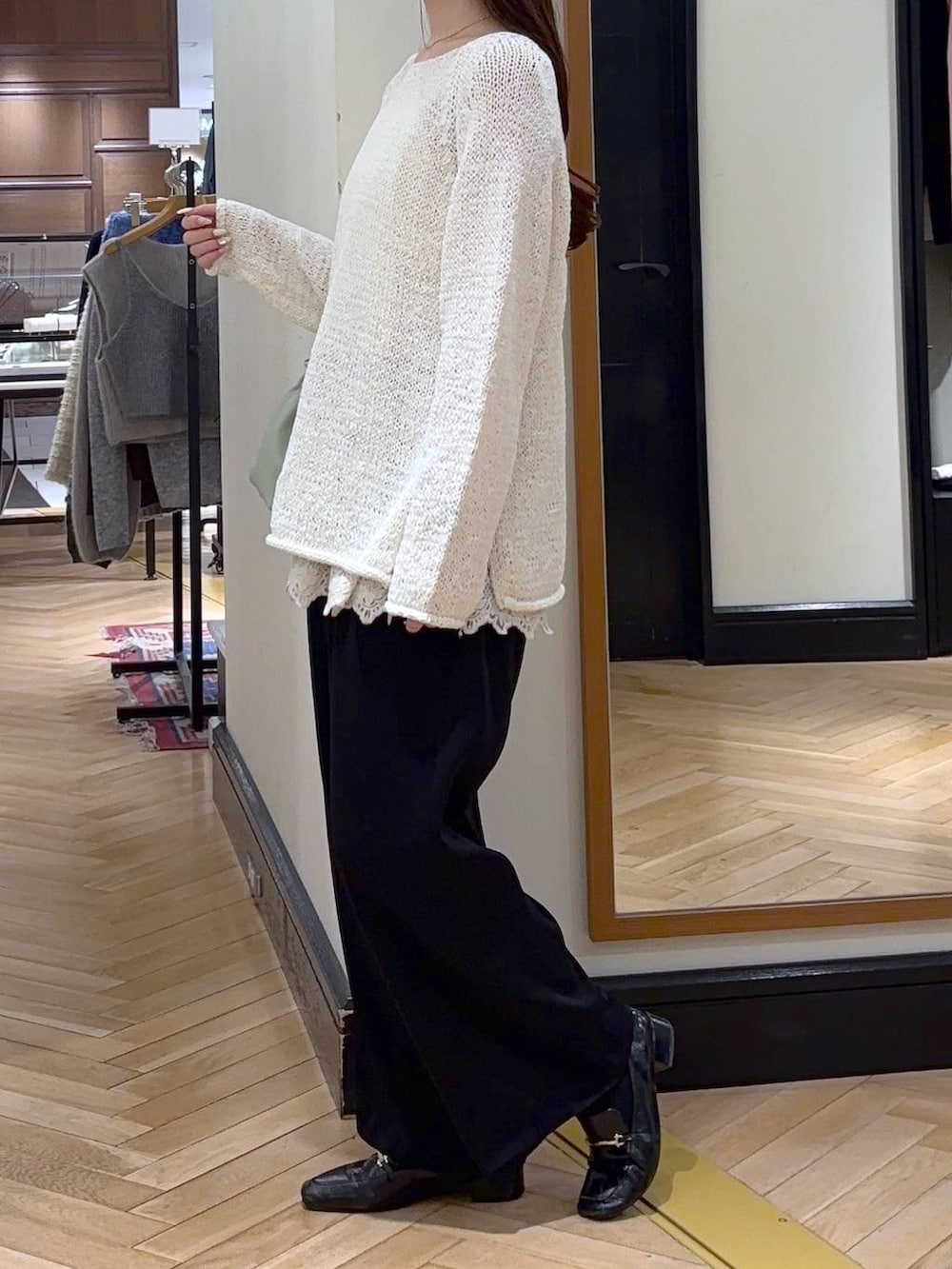 ブラック系のローファー、ブラック系のスラックス、グリーン系のショルダーバッグを着用したレディースの冬コーディネートの4枚目の写真