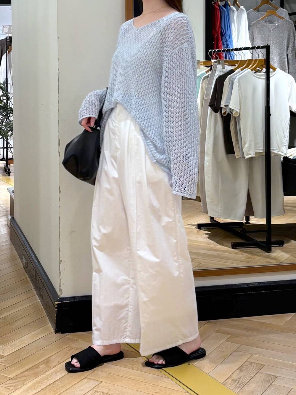 ブラック系のショルダーバッグ、ホワイト系のその他パンツ、ブルー系のニット/セーターを着用したレディースの春コーディネートの3枚目の写真