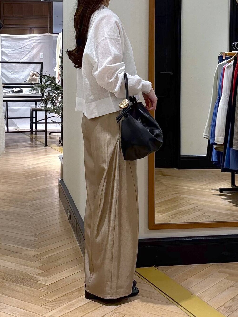 ブラック系のローファー、ベージュ系のその他パンツ、ブラック系のショルダーバッグを着用したレディースの春コーディネートの3枚目の写真