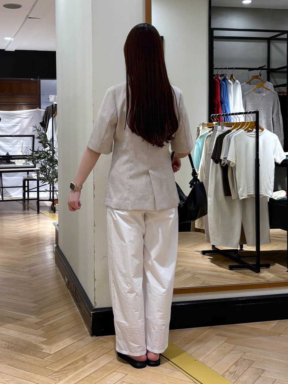 ブラック系のショルダーバッグ、ホワイト系のその他パンツ、ベージュ系のノーカラージャケットを着用したレディースの春コーディネートの4枚目の写真