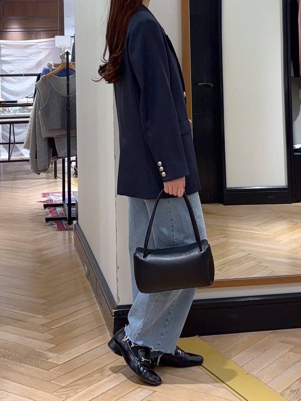 ブラック系のローファー、ブルー系のデニムパンツ、ブルー系のテーラードジャケットを着用したレディースの冬コーディネートの3枚目の写真