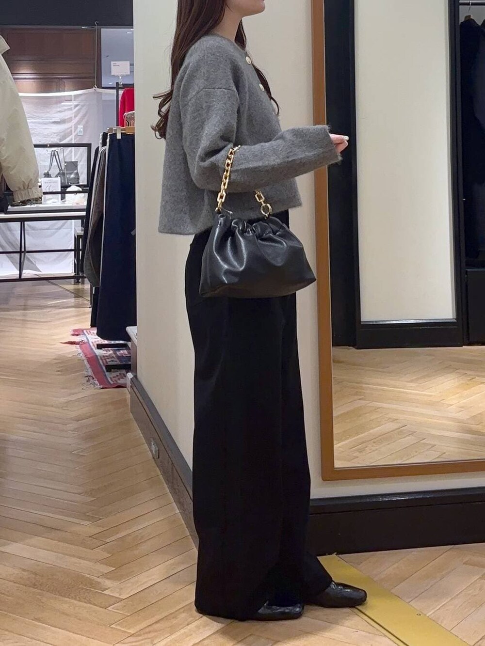 ブラック系のデニムパンツ、ブラック系のローファー、ブラック系のショルダーバッグを着用したレディースの秋コーディネートの4枚目の写真