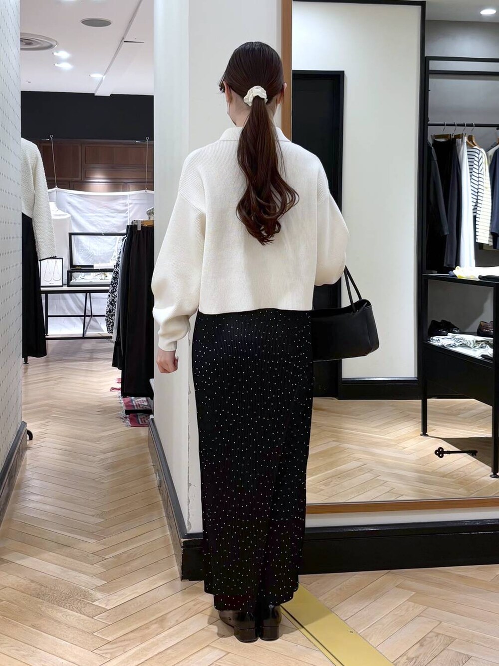 ブラック系のローファー、その他のスカート、ブラック系のショルダーバッグを着用したレディースの冬コーディネートの5枚目の写真