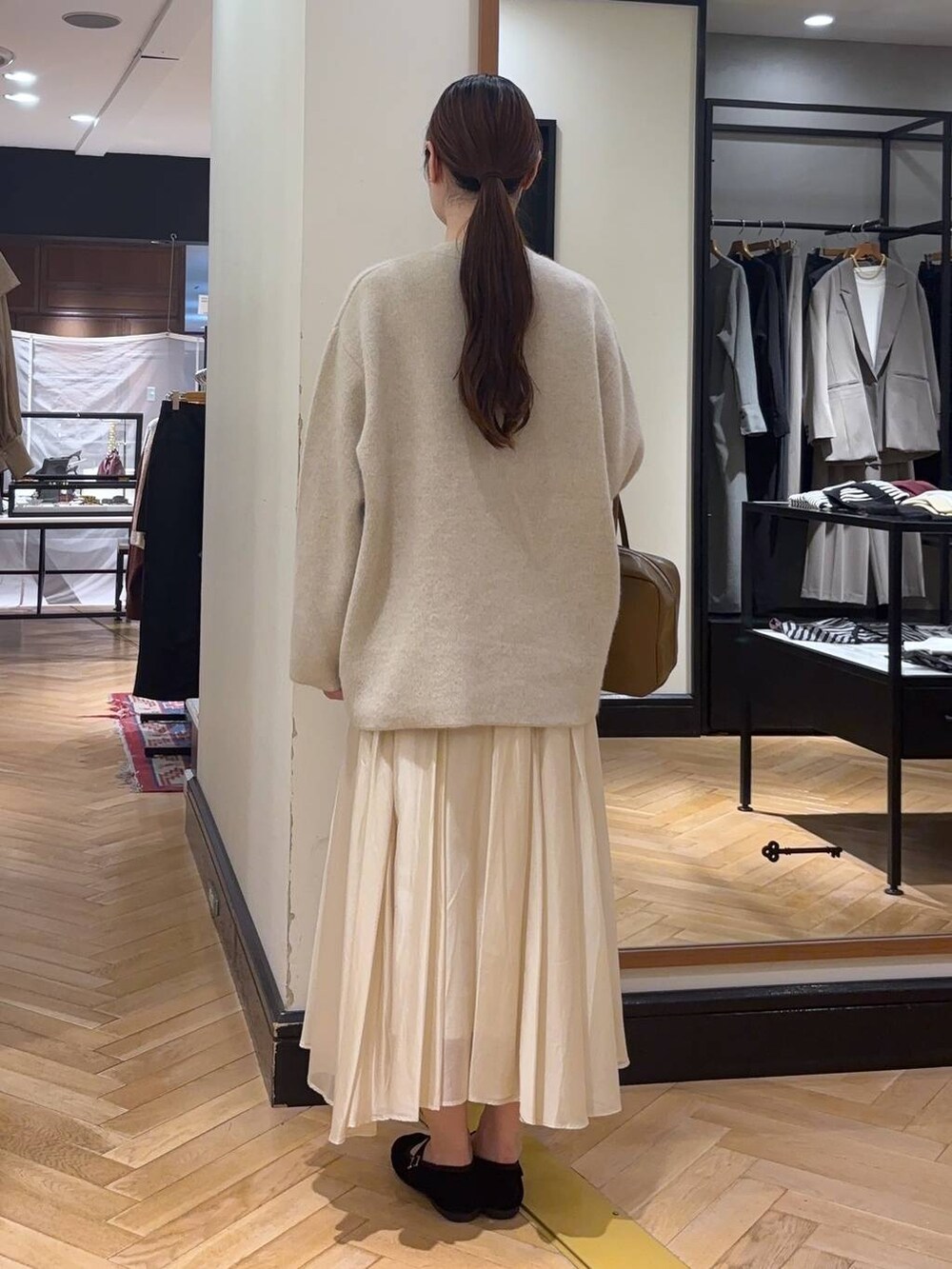 ホワイト系のカーディガン/ボレロ、ブラウン系のボストンバッグ、ブラック系のバレエシューズを着用したレディースの秋コーディネートの5枚目の写真