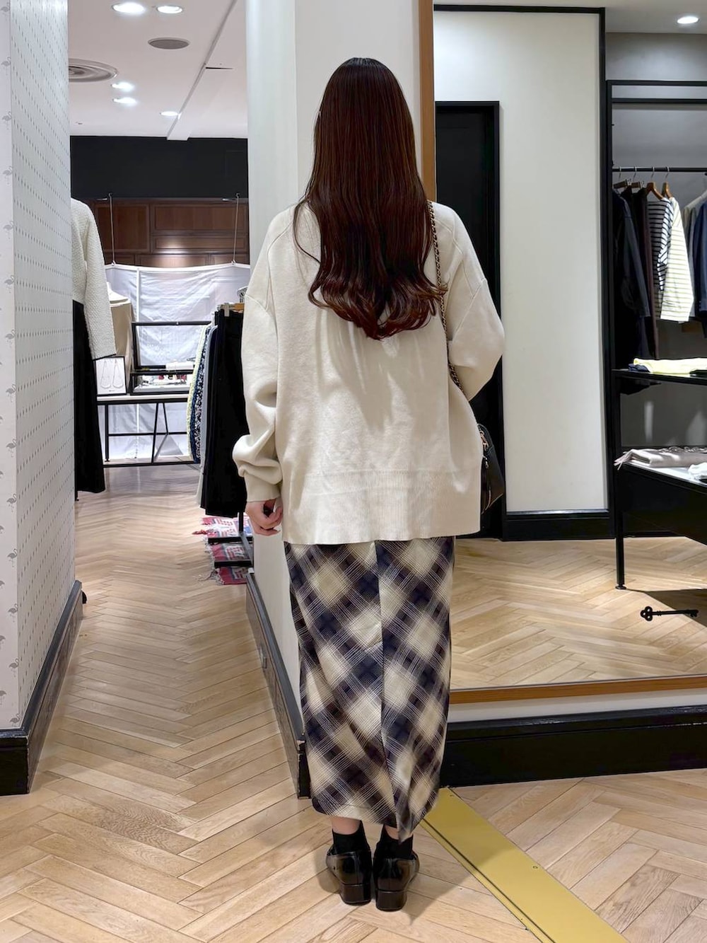 ブラック系のローファー、ホワイト系のカーディガン/ボレロ、ブラック系のショルダーバッグを着用したレディースの冬コーディネートの4枚目の写真