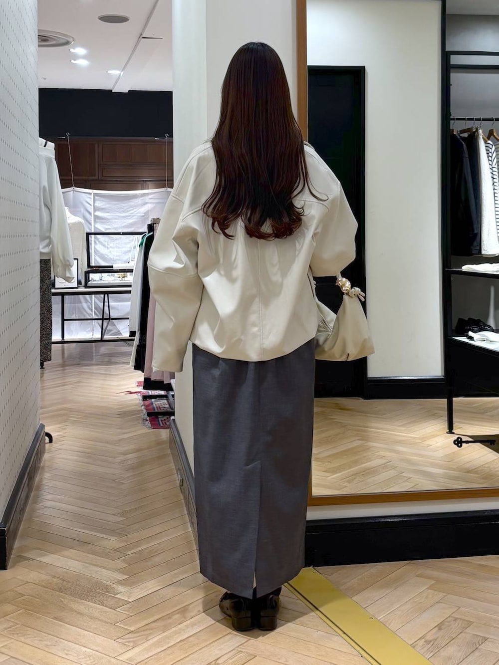 ブラック系のローファー、ホワイト系のブルゾン、グレー系のワンピースを着用したレディースの春コーディネートの4枚目の写真