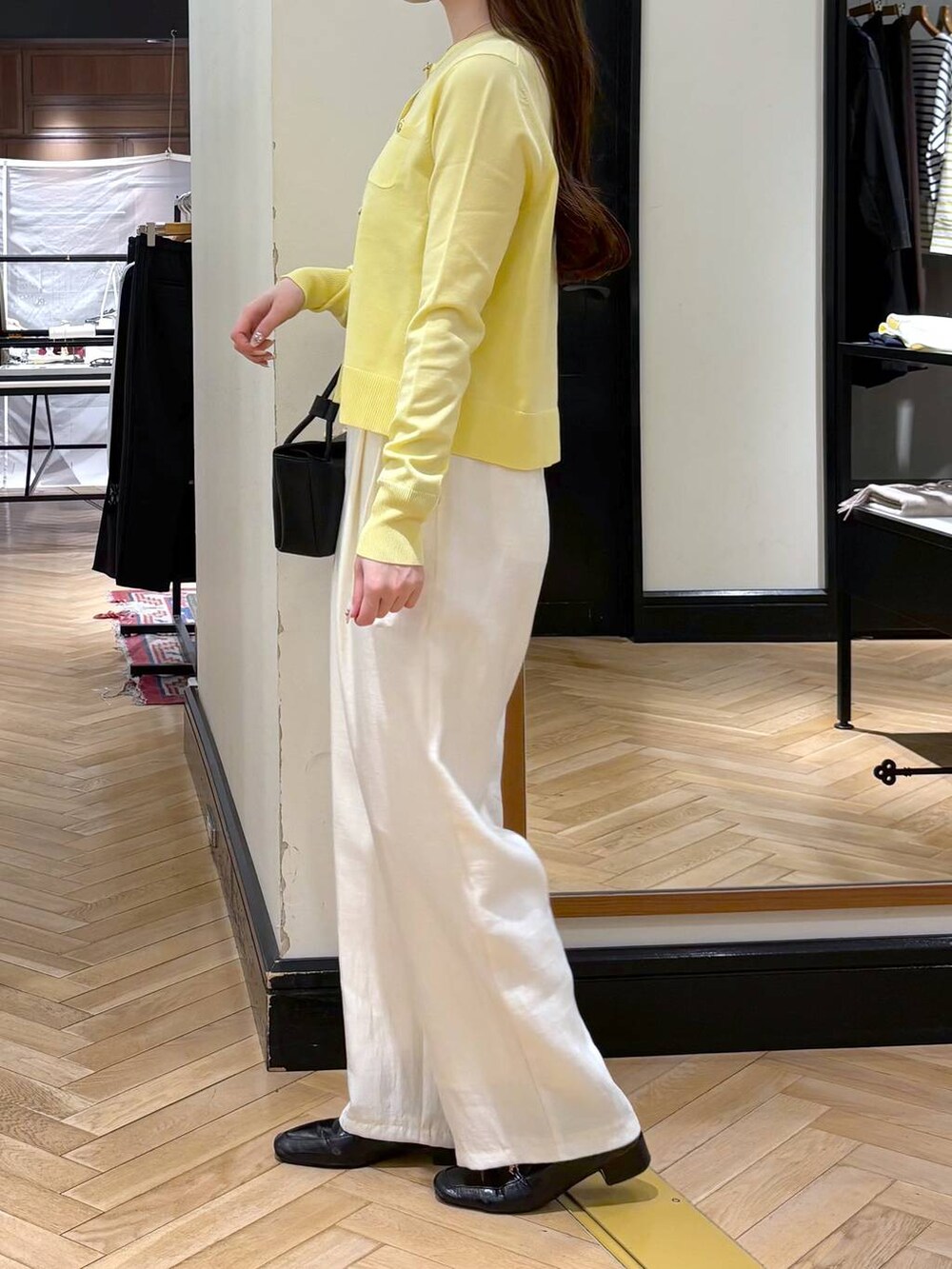 ブラック系のローファー、ブラック系のショルダーバッグ、イエロー系のカーディガン/ボレロを着用したレディースの冬コーディネートの4枚目の写真