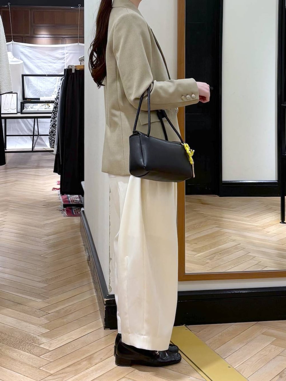 ホワイト系のスラックス、ブラック系のローファー、ベージュ系のテーラードジャケットを着用したレディースの冬コーディネートの2枚目の写真