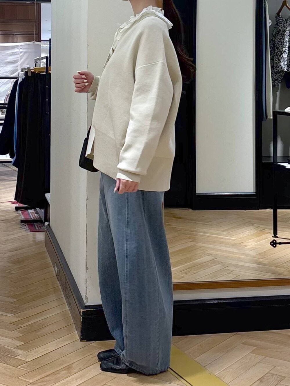 ブルー系のデニムパンツ、ブラック系のローファー、ホワイト系のカーディガン/ボレロを着用したレディースの冬コーディネートの3枚目の写真