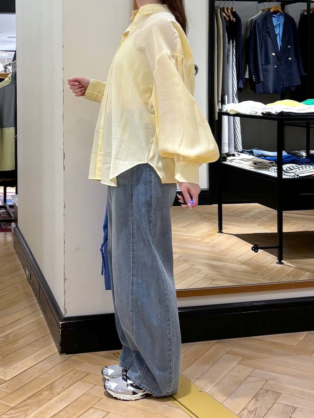 ブルー系のデニムパンツ、シルバー系のスニーカー、イエロー系のシャツ/ブラウスを着用したレディースの春コーディネートの3枚目の写真