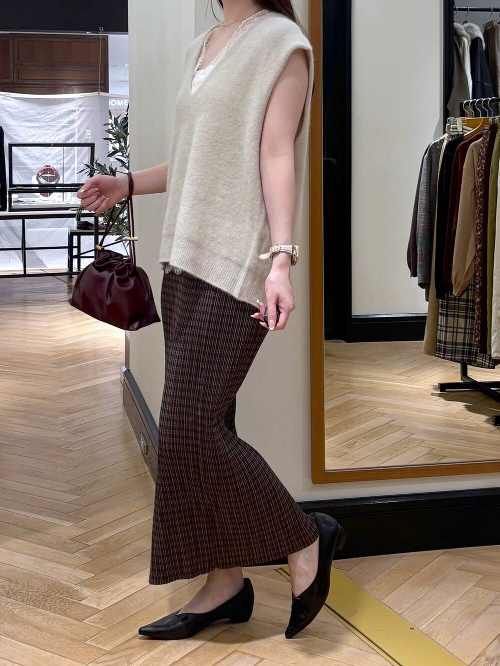 レッド系のショルダーバッグ、ブラック系のパンプス、その他のスカートを着用したレディースの秋コーディネートの3枚目の写真
