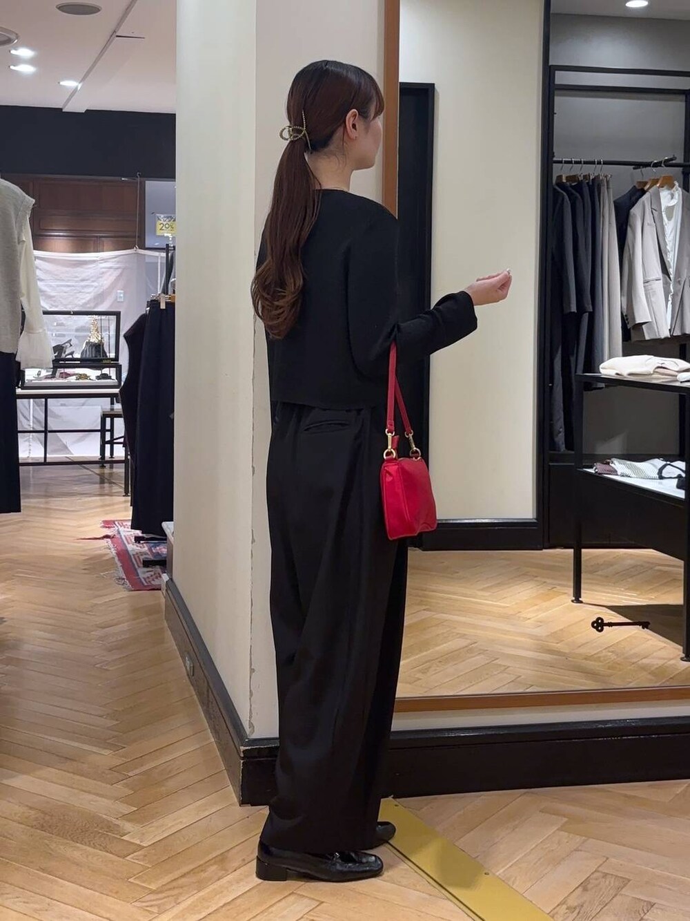 ブラック系のローファー、ブラック系のスラックス、レッド系のショルダーバッグを着用したレディースの秋コーディネートの4枚目の写真