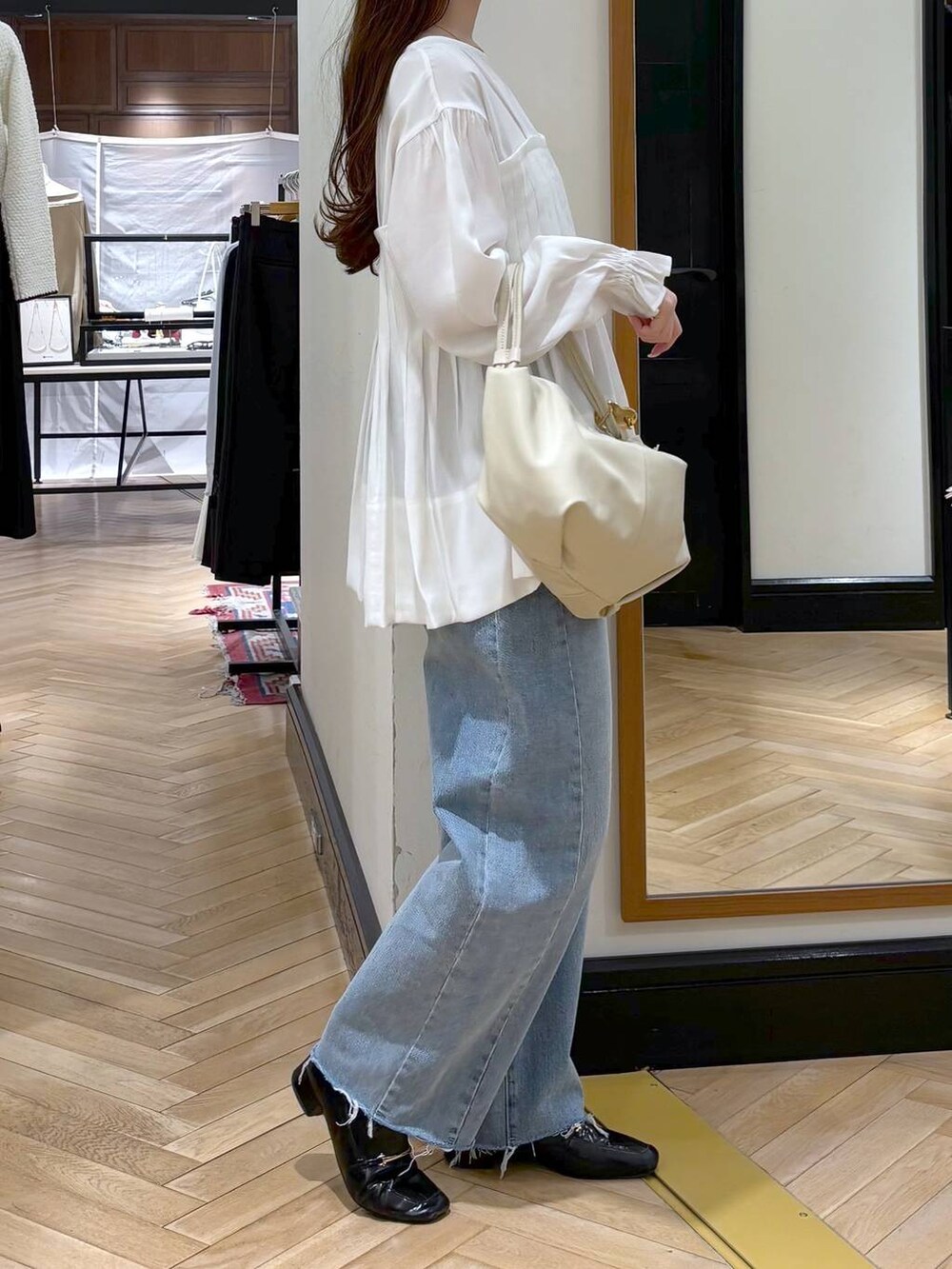 ブラック系のローファー、ブルー系のデニムパンツ、ホワイト系のシャツ/ブラウスを着用したレディースの冬コーディネートの2枚目の写真