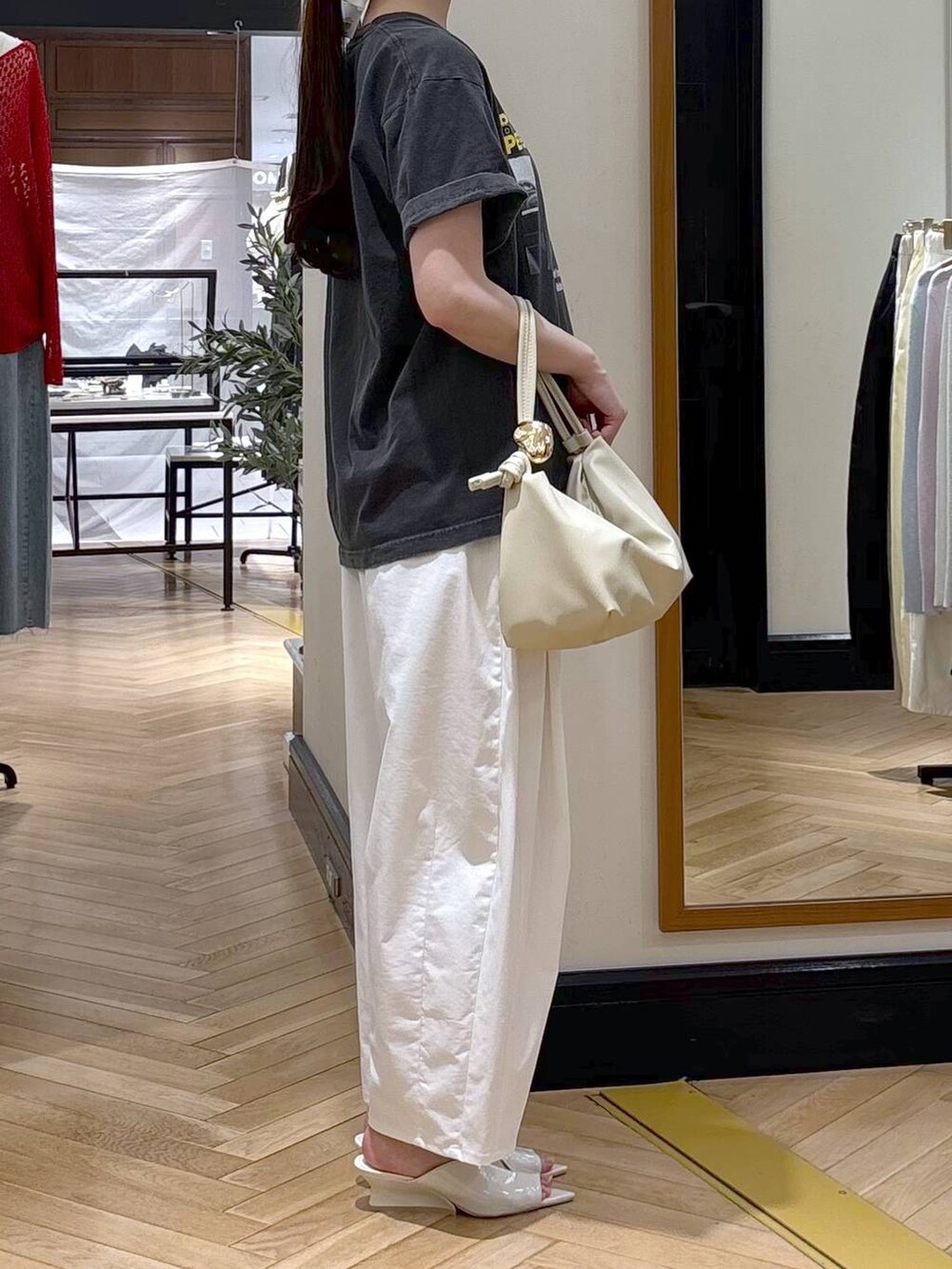 ホワイト系のショルダーバッグ、グレー系のTシャツ/カットソー、ホワイト系のサンダルを着用したレディースの春コーディネートの2枚目の写真