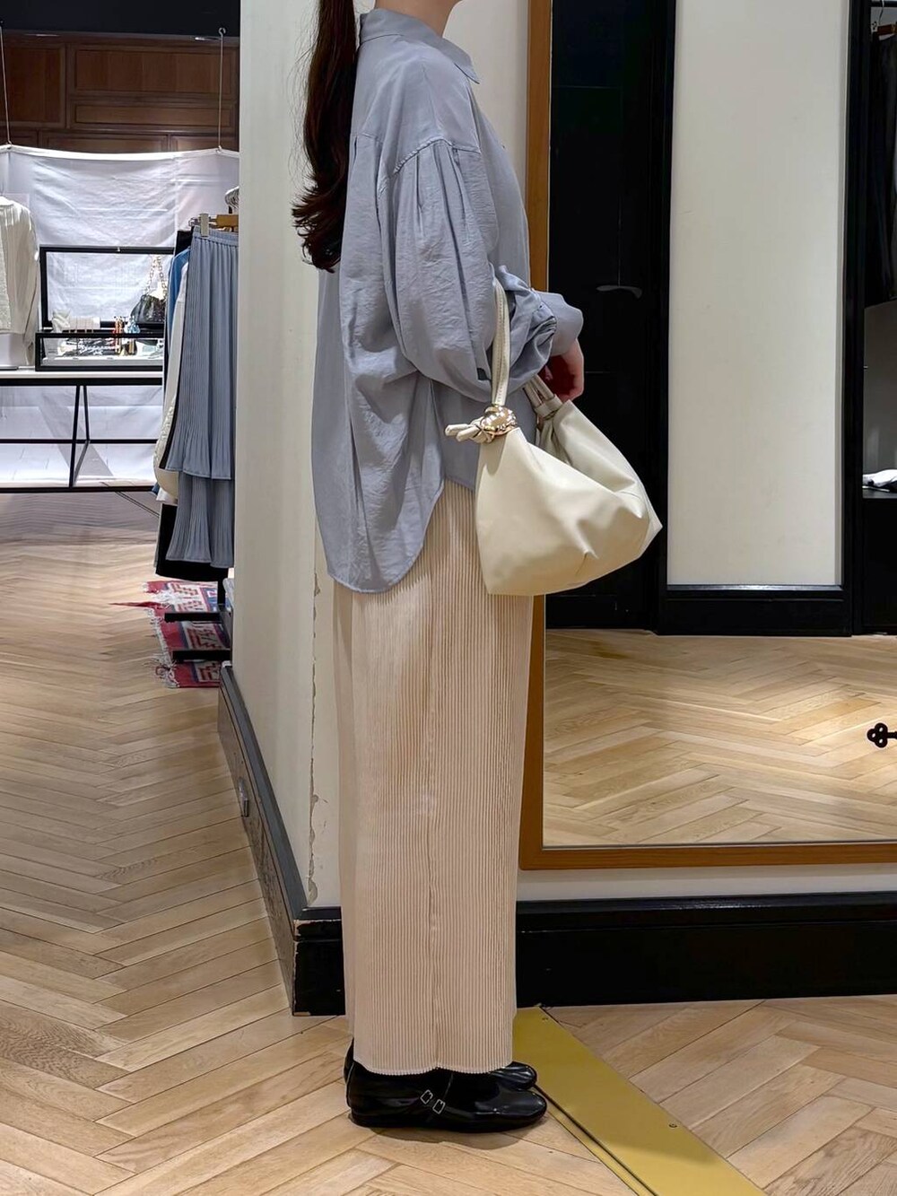 ホワイト系のスカート、ベージュ系のショルダーバッグ、ブルー系のシャツ/ブラウスを着用したレディースの春コーディネートの2枚目の写真