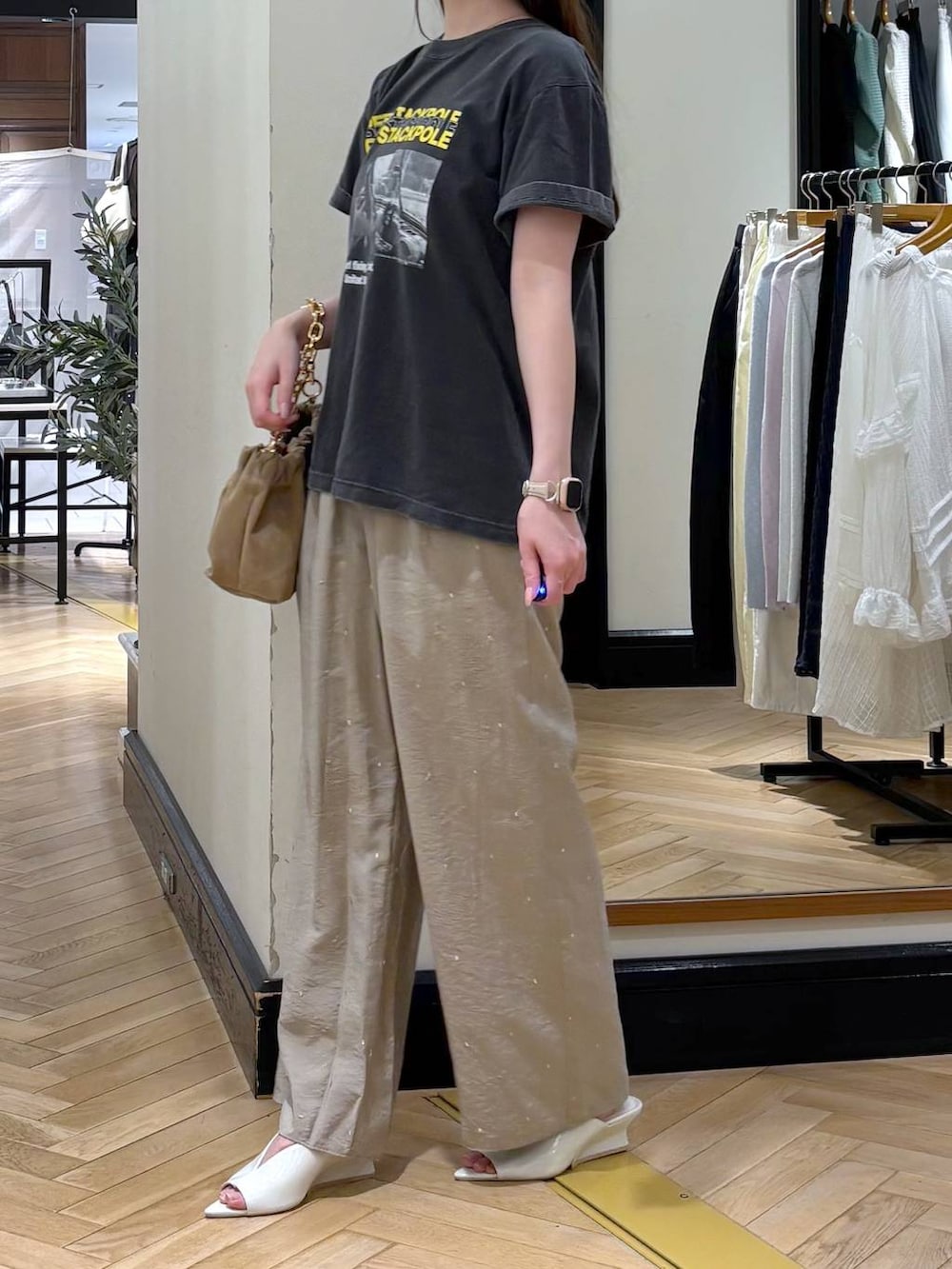 ベージュ系のショルダーバッグ、グレー系のTシャツ/カットソー、ホワイト系のサンダルを着用したレディースの春コーディネートの3枚目の写真