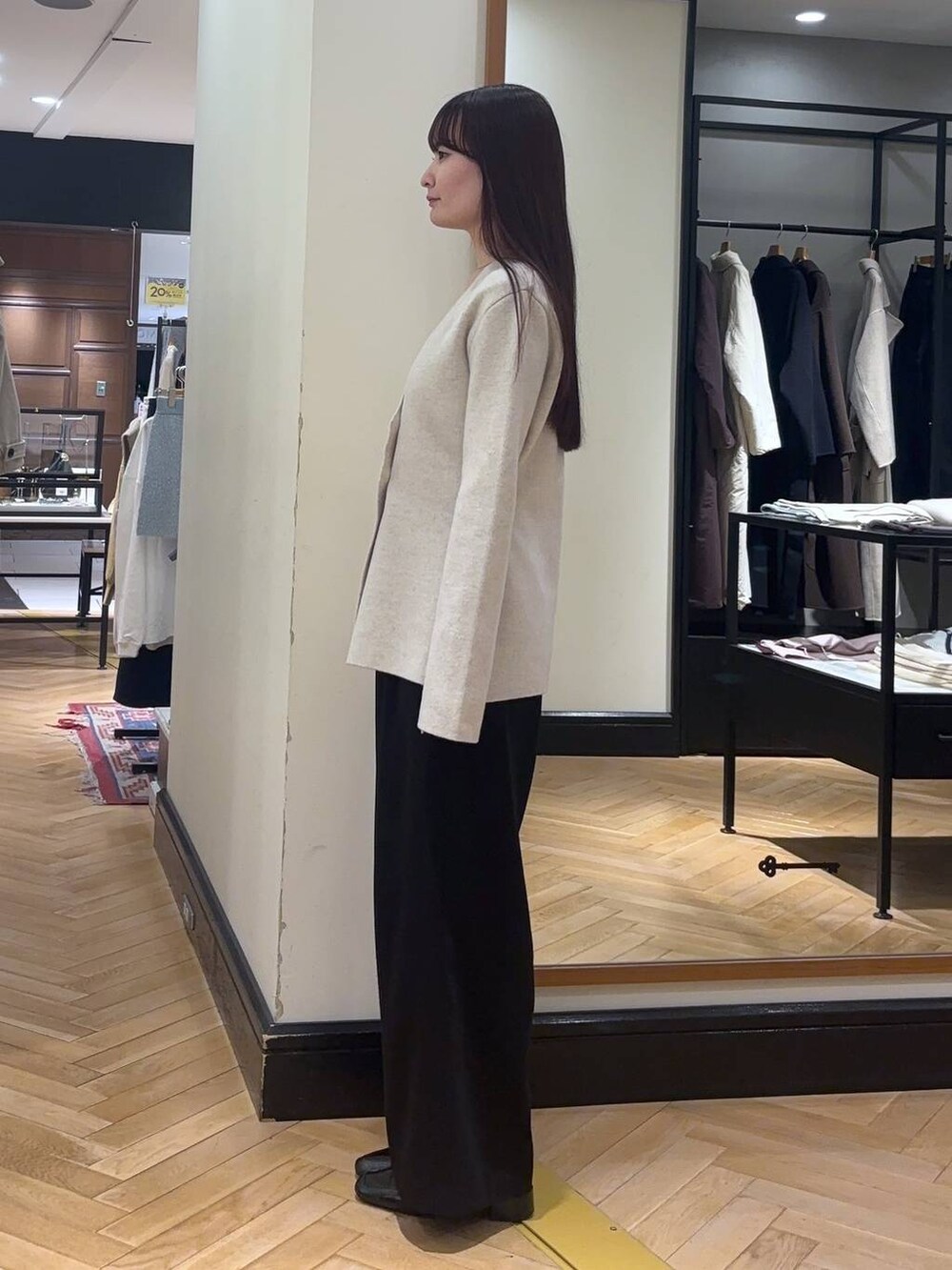 ブラック系のローファー、ブラック系のスラックス、ホワイト系のノーカラージャケットを着用したレディースの秋コーディネートの5枚目の写真