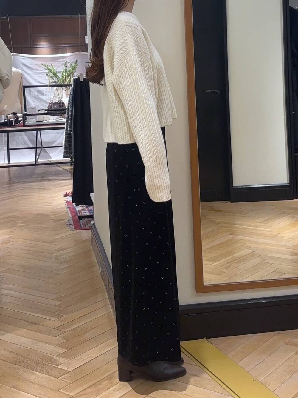 ホワイト系のピーコート、ブラウン系のブーツ、ホワイト系のニット/セーターを着用したレディースの冬コーディネートの5枚目の写真