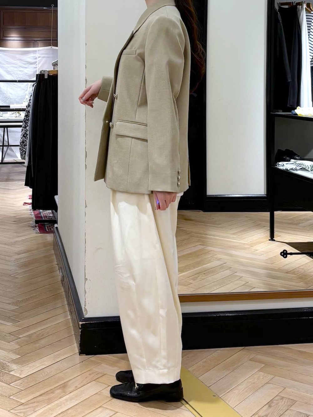 ホワイト系のスラックス、ブラック系のローファー、ベージュ系のテーラードジャケットを着用したレディースの冬コーディネートの3枚目の写真