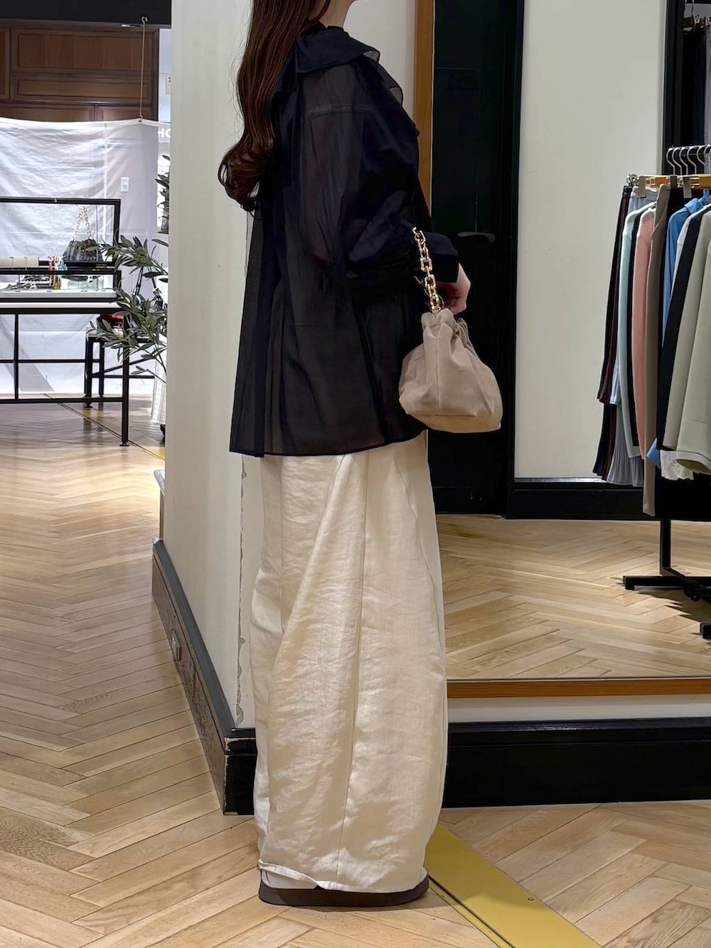 ホワイト系のその他パンツ、ベージュ系のショルダーバッグ、ブラック系のシャツ/ブラウスを着用したレディースの春コーディネートの2枚目の写真