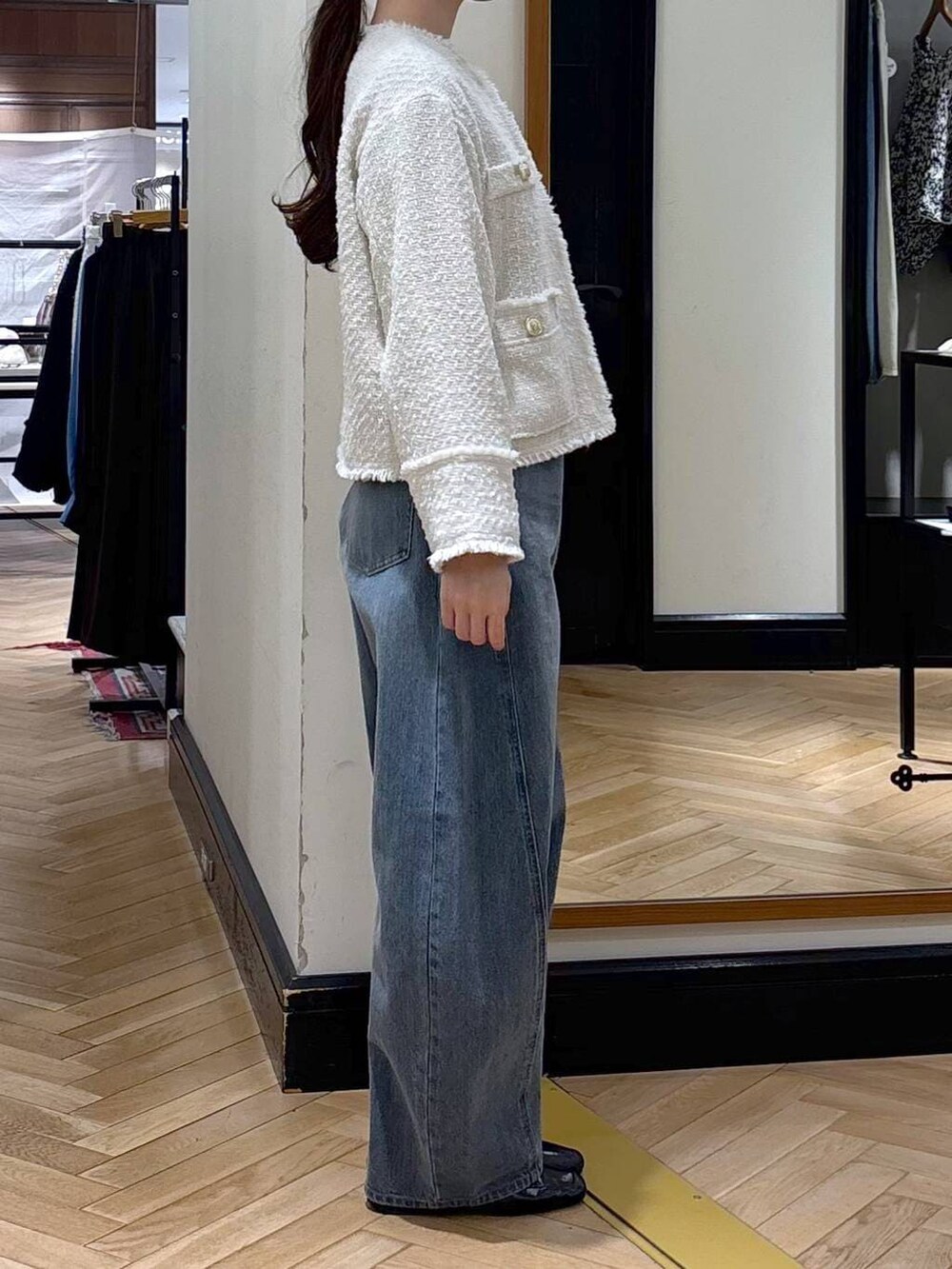 ブルー系のデニムパンツ、ブラック系のローファー、ホワイト系のノーカラージャケットを着用したレディースの冬コーディネートの4枚目の写真