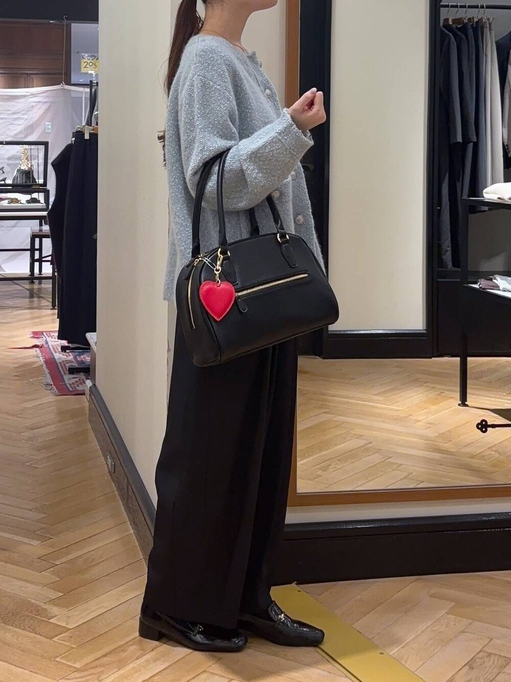 ブラック系のローファー、ブルー系のカーディガン/ボレロ、ブラック系のスラックスを着用したレディースの秋コーディネートの2枚目の写真