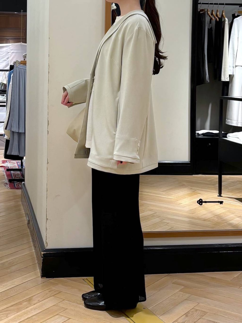 ブラック系のスカート、ベージュ系のショルダーバッグ、ベージュ系のテーラードジャケットを着用したレディースの春コーディネートの3枚目の写真