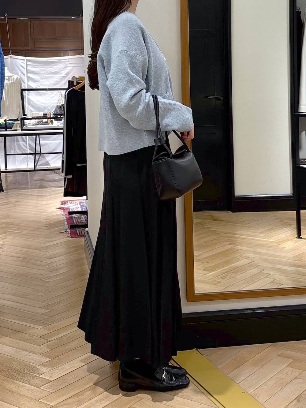 ブラック系のローファー、ブルー系のカーディガン/ボレロ、ブラック系のショルダーバッグを着用したレディースの春コーディネートの2枚目の写真