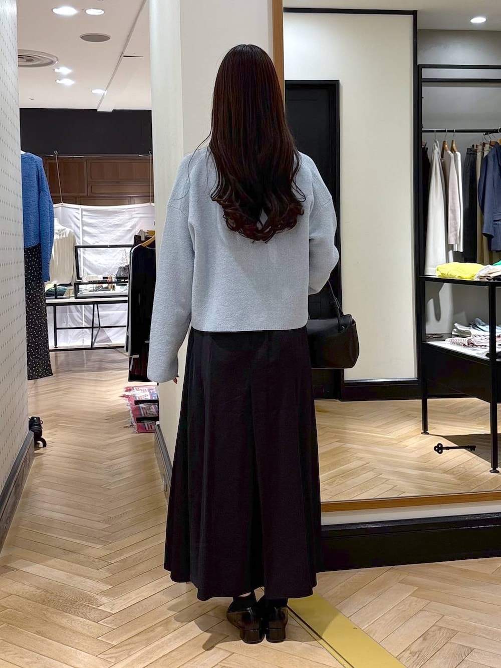 ブラック系のローファー、ブルー系のカーディガン/ボレロ、ブラック系のショルダーバッグを着用したレディースの春コーディネートの4枚目の写真