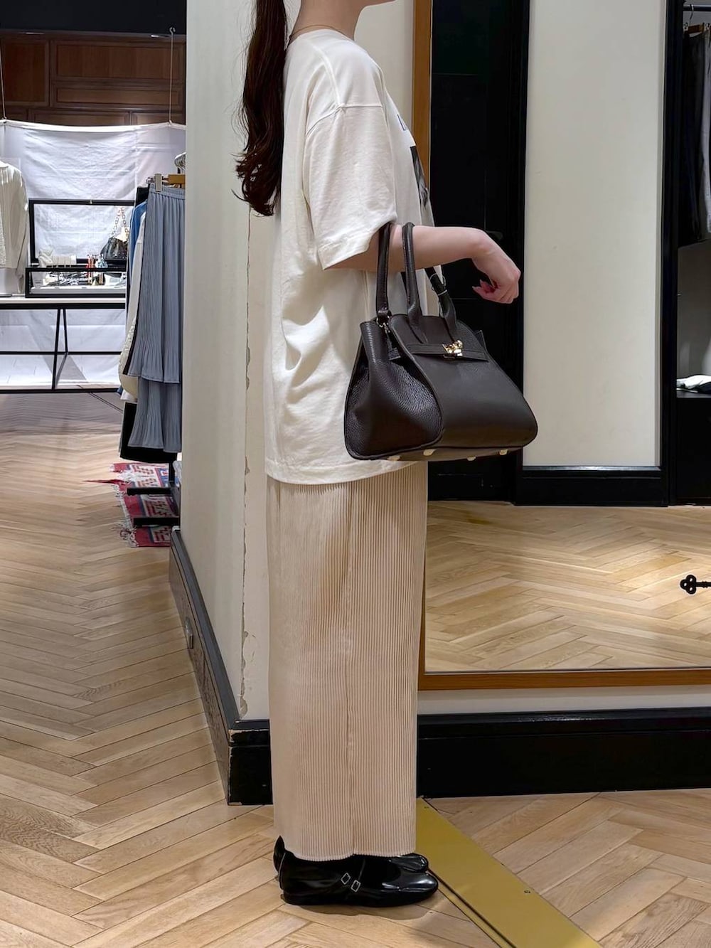 ホワイト系のスカート、ブラック系のショルダーバッグ、ブルー系のTシャツ/カットソーを着用したレディースの春コーディネートの2枚目の写真