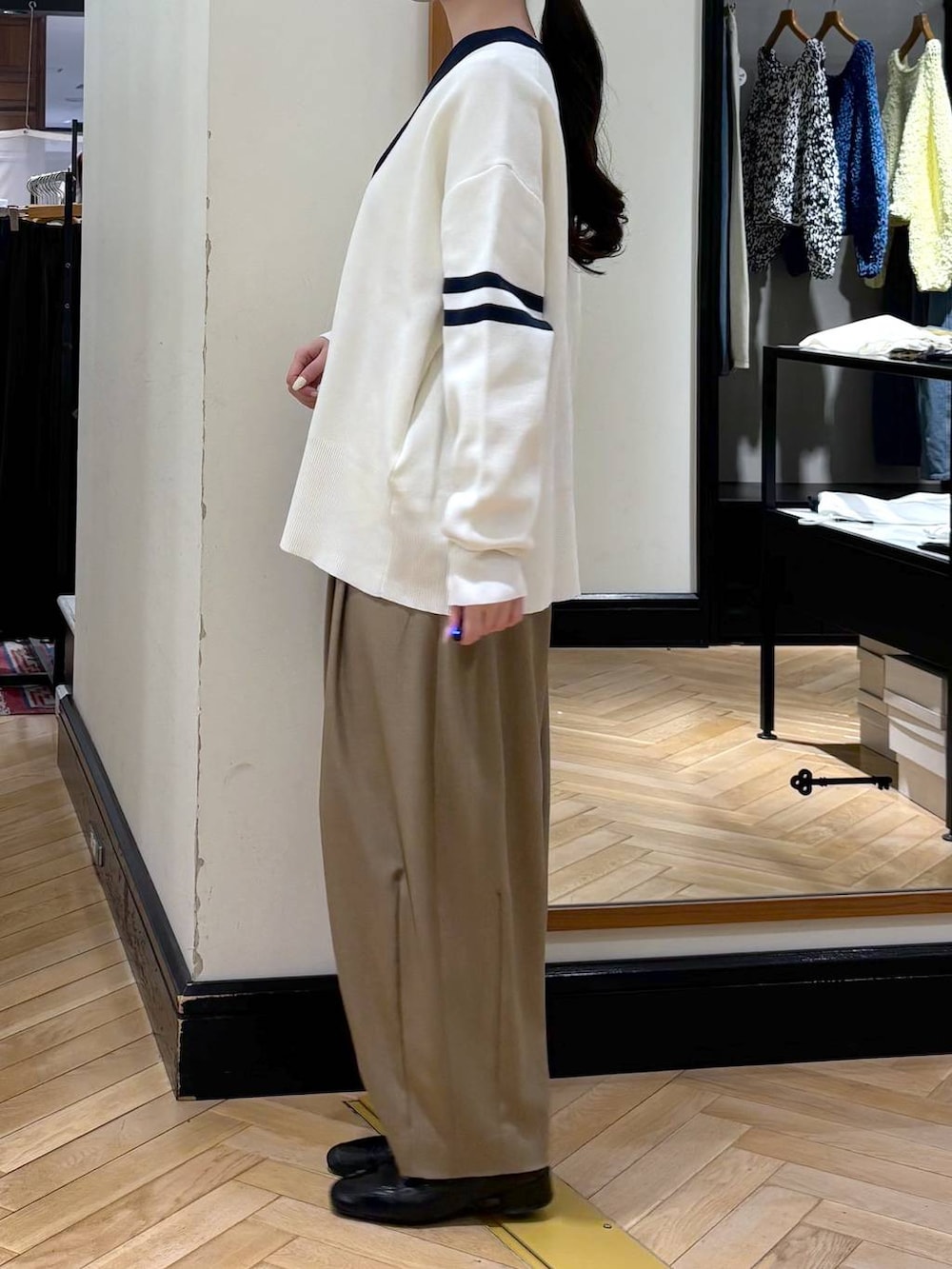 ベージュ系のスラックス、ブラック系のローファー、ブラック系のカーディガン/ボレロを着用したレディースの冬コーディネートの4枚目の写真