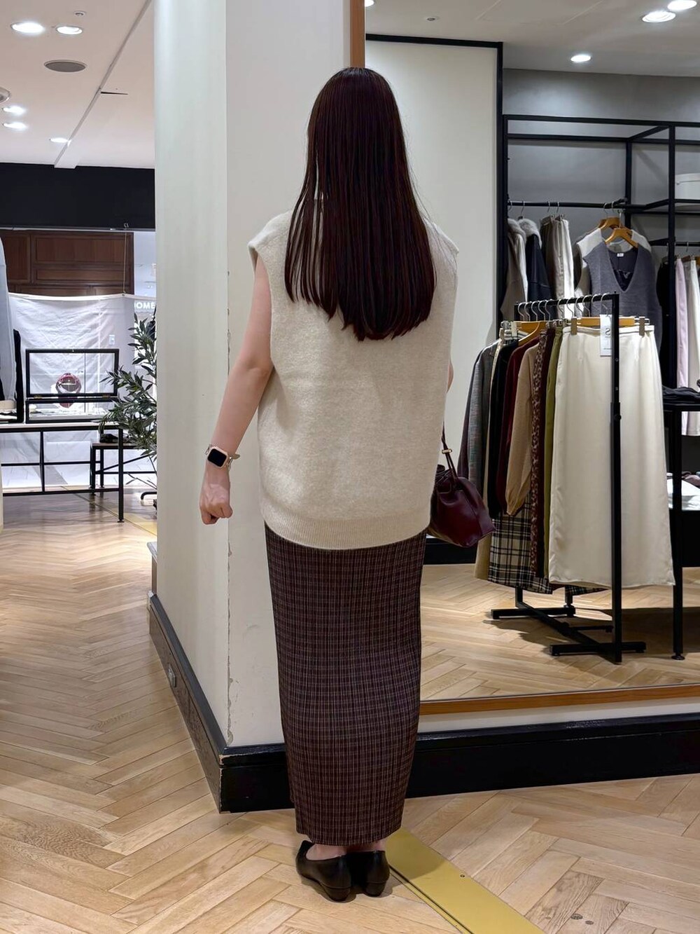 レッド系のショルダーバッグ、ブラック系のパンプス、その他のスカートを着用したレディースの秋コーディネートの4枚目の写真