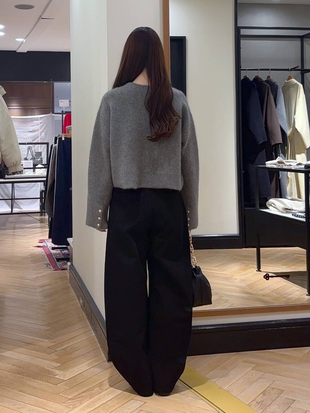 ブラック系のデニムパンツ、ブラック系のローファー、ブラック系のショルダーバッグを着用したレディースの秋コーディネートの5枚目の写真