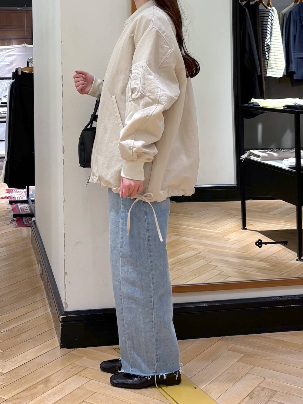 ブラック系のローファー、ベージュ系のMA-1、ブルー系のデニムパンツを着用したレディースの冬コーディネートの5枚目の写真