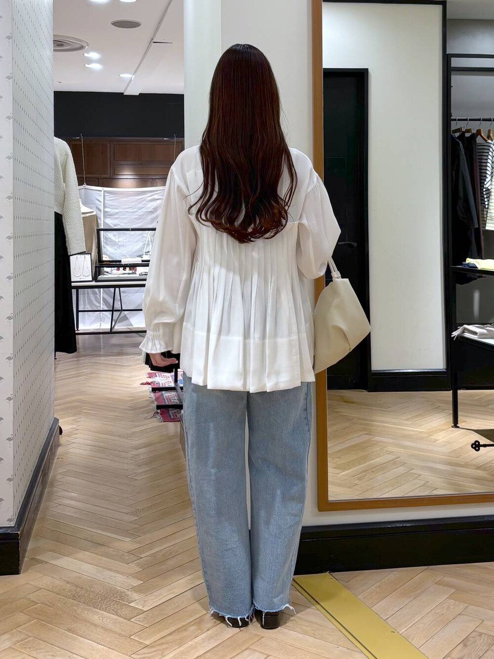 ブラック系のローファー、ブルー系のデニムパンツ、ホワイト系のシャツ/ブラウスを着用したレディースの冬コーディネートの5枚目の写真