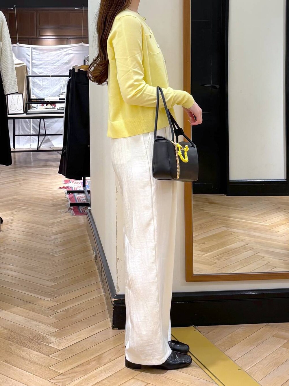 ブラック系のローファー、ブラック系のショルダーバッグ、イエロー系のカーディガン/ボレロを着用したレディースの冬コーディネートの3枚目の写真