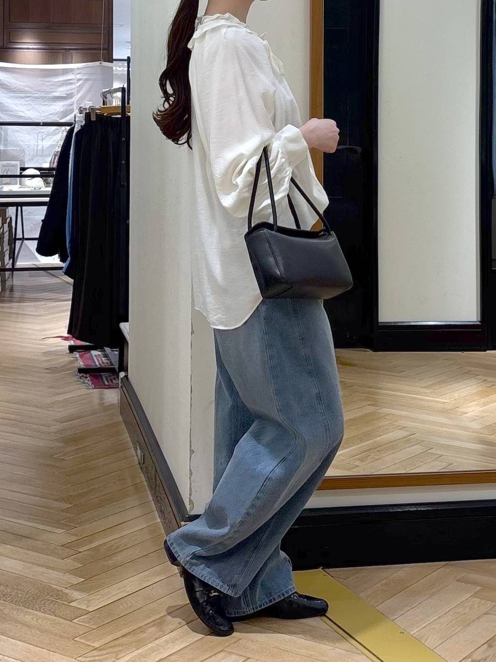 ブルー系のデニムパンツ、ブラック系のローファー、ホワイト系のシャツ/ブラウスを着用したレディースの冬コーディネートの4枚目の写真