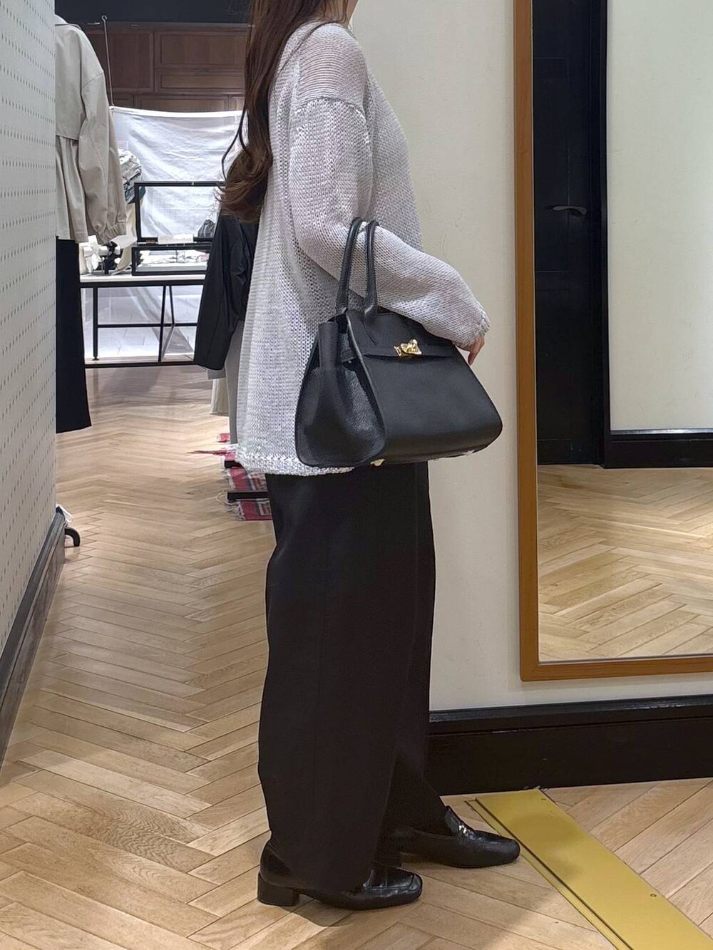 ブラック系のローファー、ブラック系のショルダーバッグ、ブラック系のチノパンツを着用したレディースの春コーディネートの3枚目の写真