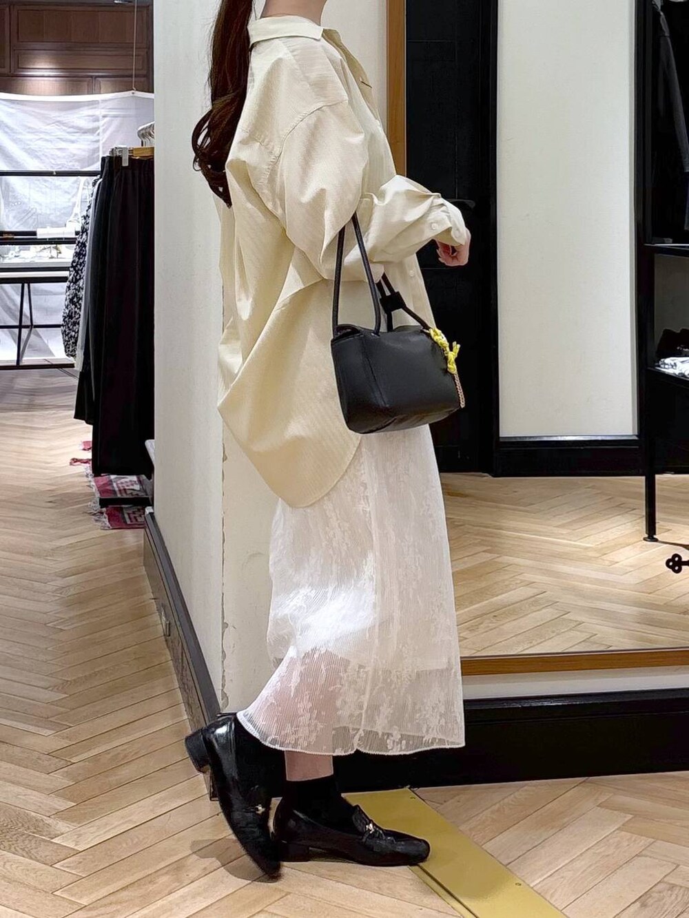 ブラック系のローファー、ホワイト系のスカート、イエロー系のシャツ/ブラウスを着用したレディースの冬コーディネートの2枚目の写真