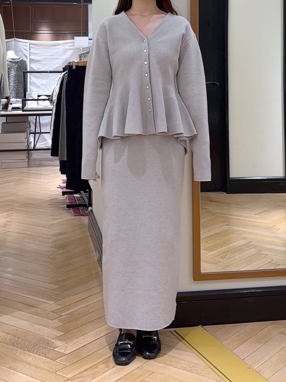 ブラック系のローファー、グレー系のワンピース、ブラウン系のショルダーバッグを着用したレディースの冬コーディネートの2枚目の写真