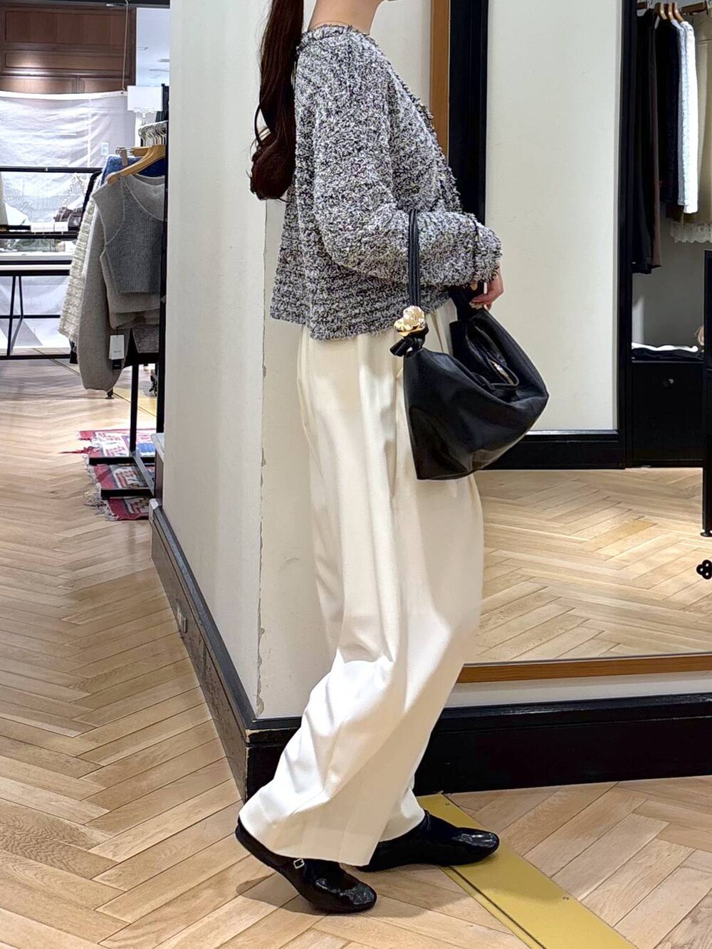 ホワイト系のスラックス、ブラック系のショルダーバッグ、ブラック系のカーディガン/ボレロを着用したレディースの冬コーディネートの3枚目の写真