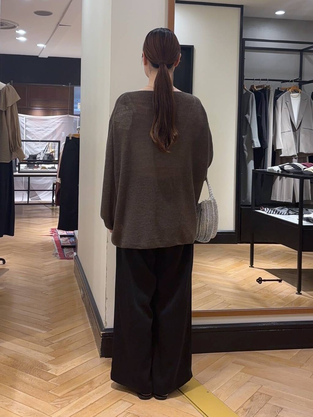 ブラウン系のニット/セーター、ブラック系のサンダル、シルバー系のハンドバッグを着用したレディースの秋コーディネートの4枚目の写真