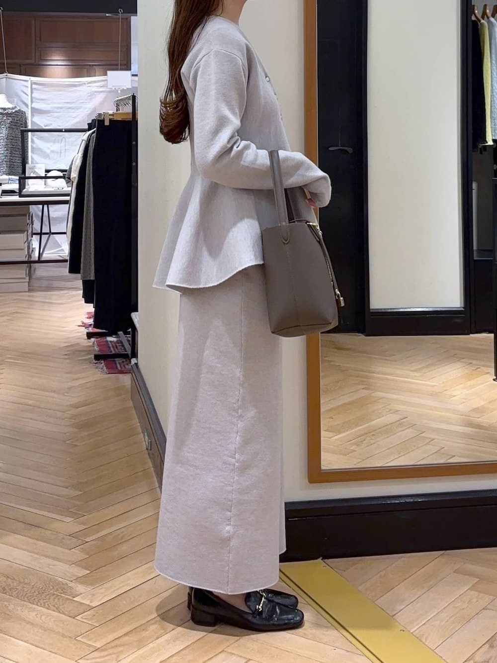 ブラック系のローファー、グレー系のワンピース、ブラウン系のショルダーバッグを着用したレディースの冬コーディネートの5枚目の写真