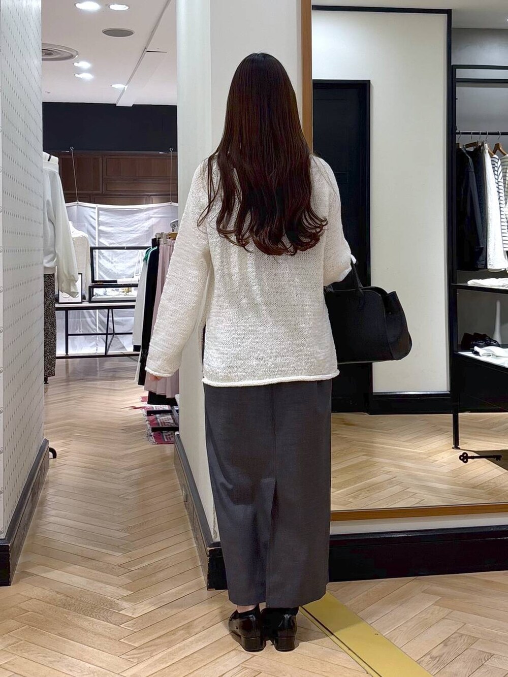 ブラック系のローファー、ブラック系のショルダーバッグ、ホワイト系のニット/セーターを着用したレディースの春コーディネートの4枚目の写真