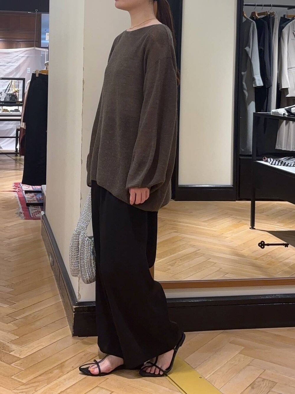 ブラウン系のニット/セーター、ブラック系のサンダル、シルバー系のハンドバッグを着用したレディースの秋コーディネートの2枚目の写真