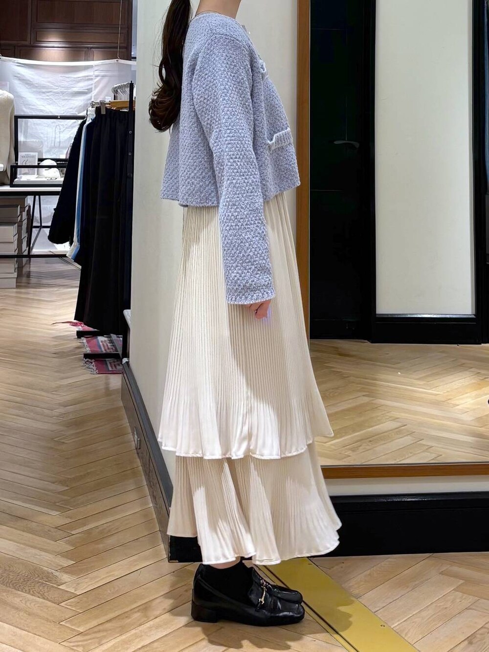 ホワイト系のスカート、ブラック系のローファー、ブルー系のカーディガン/ボレロを着用したレディースの冬コーディネートの3枚目の写真