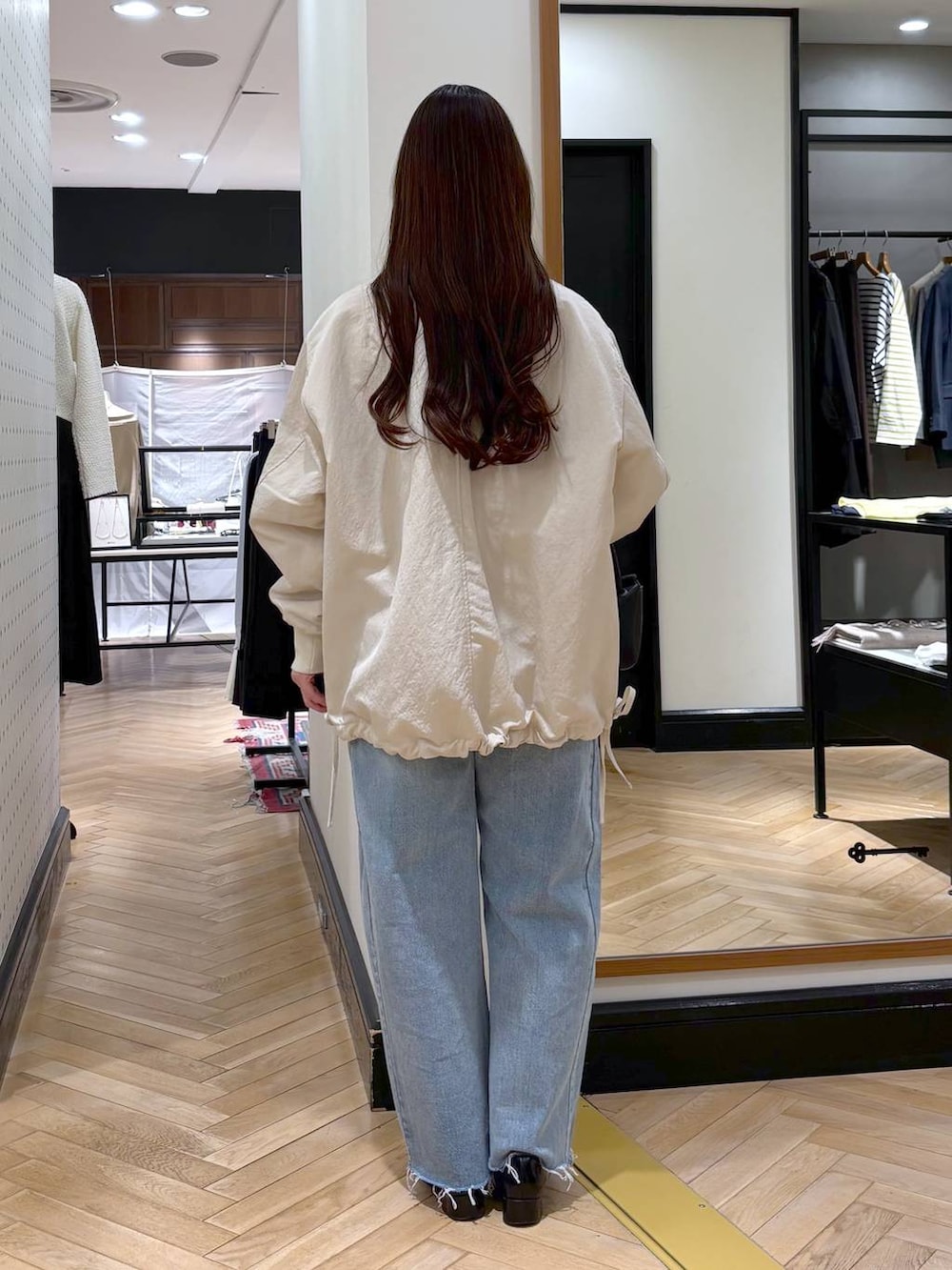 ブラック系のローファー、ベージュ系のMA-1、ブルー系のデニムパンツを着用したレディースの冬コーディネートの6枚目の写真