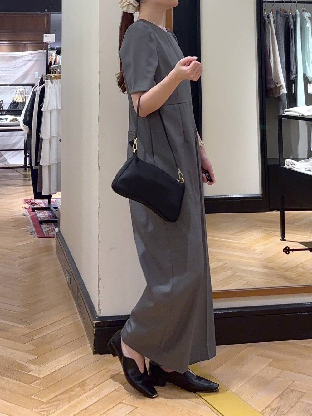 ブラック系のパンプス、ブラック系のショルダーバッグ、グレー系のつなぎ/オールインワンを着用したレディースの秋コーディネートの3枚目の写真