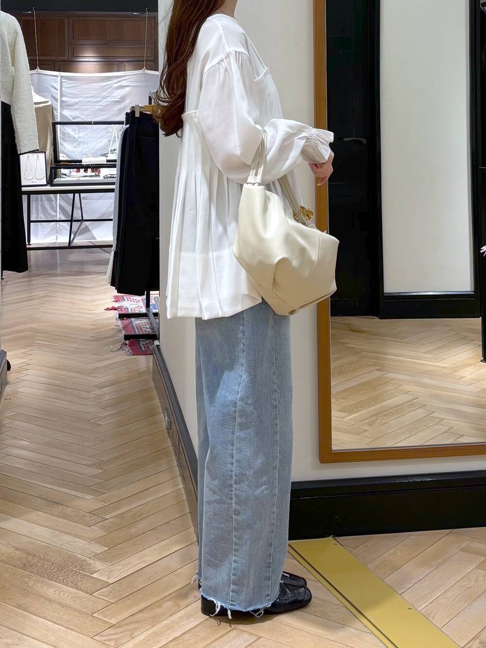 ブラック系のローファー、ブルー系のデニムパンツ、ホワイト系のシャツ/ブラウスを着用したレディースの冬コーディネートの3枚目の写真